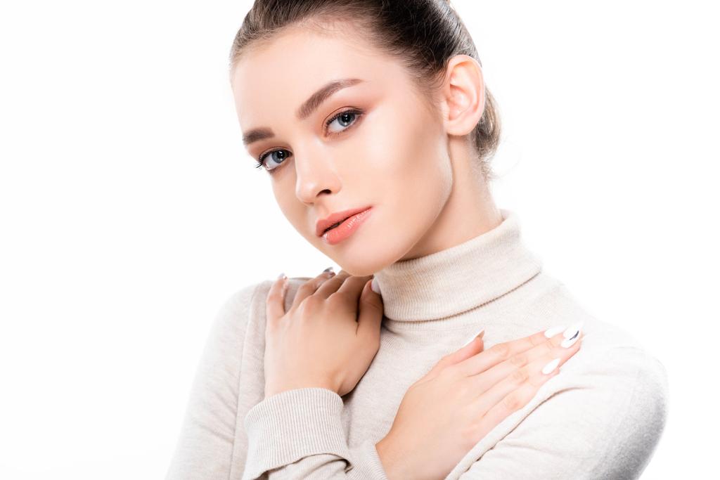 привлекательная девушка с натуральным макияжем держа руки на груди и глядя на камеру изолированы на белом
 - Фото, изображение