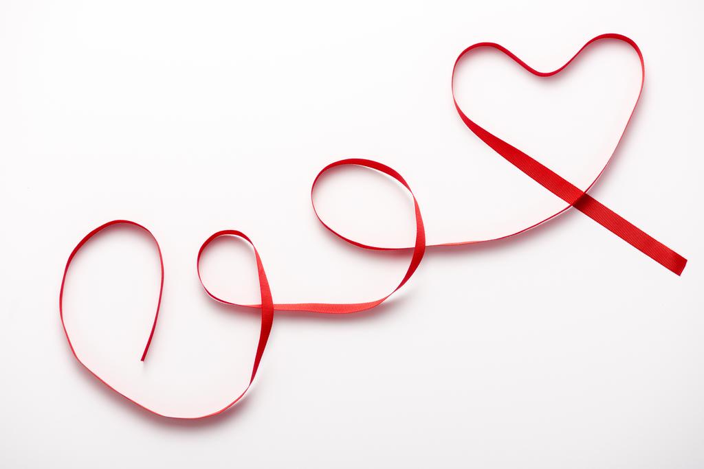 vista superior da fita vermelha em forma de coração no branco
  - Foto, Imagem