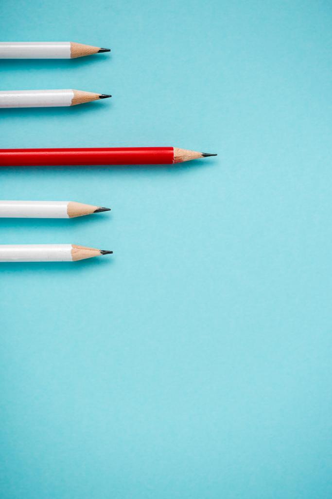 Draufsicht auf geschärfte weiße und rote Bleistifte isoliert auf blau  - Foto, Bild