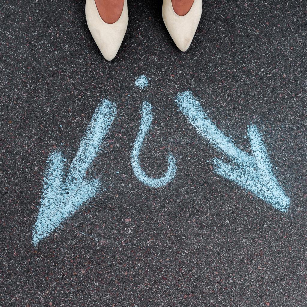vista superior de la mujer de pie cerca de flechas direccionales azules sobre asfalto
  - Foto, Imagen