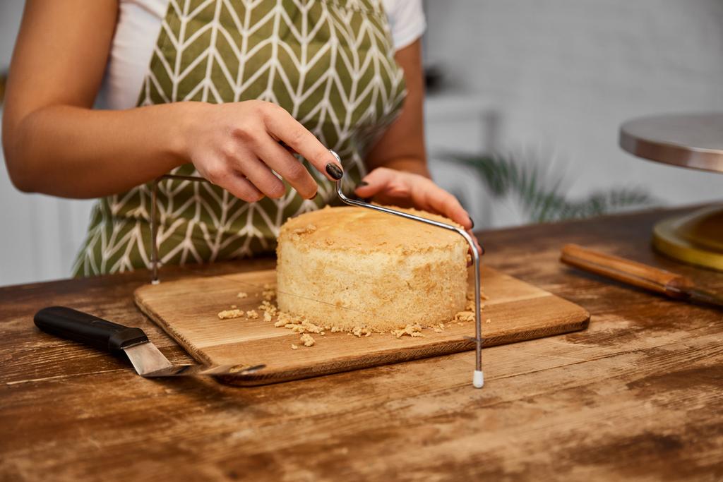 Gedeeltelijke weergave van snoepgoed snijden taart met taart snijder    - Foto, afbeelding