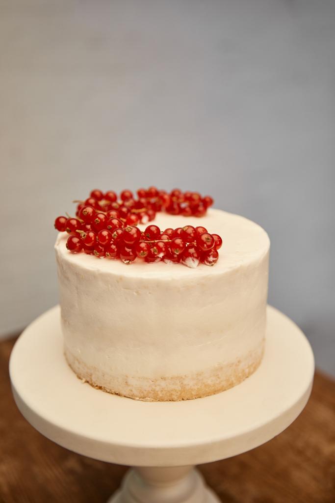 Lekkere spons cake met room en verse rode bessen op cake stand - Foto, afbeelding