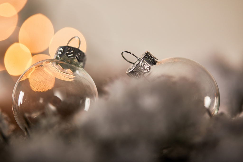 прозрачные рождественские шарики на еловых ветвях в снегу с желтыми огнями боке
 - Фото, изображение