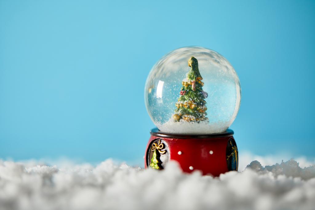 雪と青の上に立つ雪玉のクリスマスツリー  - 写真・画像