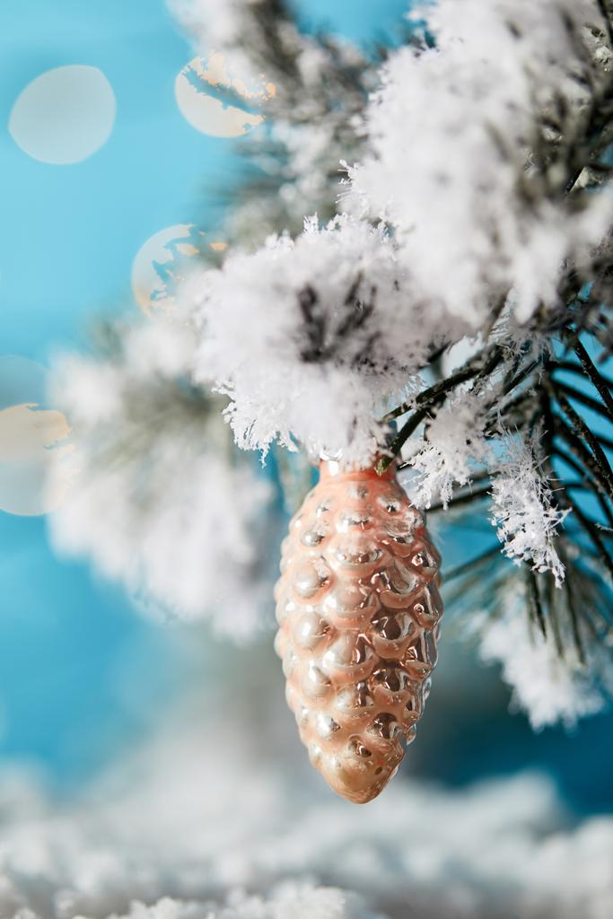 close up of spruce branches in snow with christmas ball pine cone on blue - Photo, Image