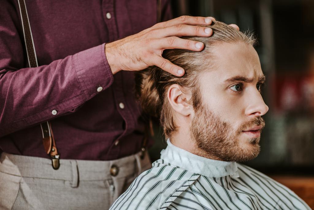 fryzjer kładzie ręce na słuch o przystojnym brodatym mężczyźnie  - Zdjęcie, obraz
