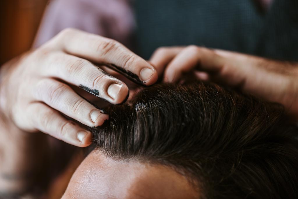 黒い髪のポマードを持つ床屋のクロップドビューの男の髪のスタイリング  - 写真・画像