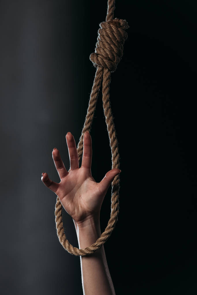 bijgesneden met vrouwelijke hand in opknoping touw strop op zwarte achtergrond - Foto, afbeelding