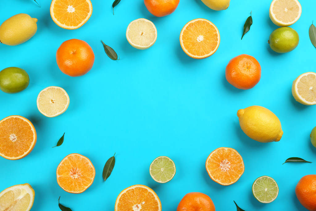 Płaska kompozycja świecka z mandarynkami i różnymi owocami cytrusowymi na niebieskim tle. Miejsce na tekst - Zdjęcie, obraz