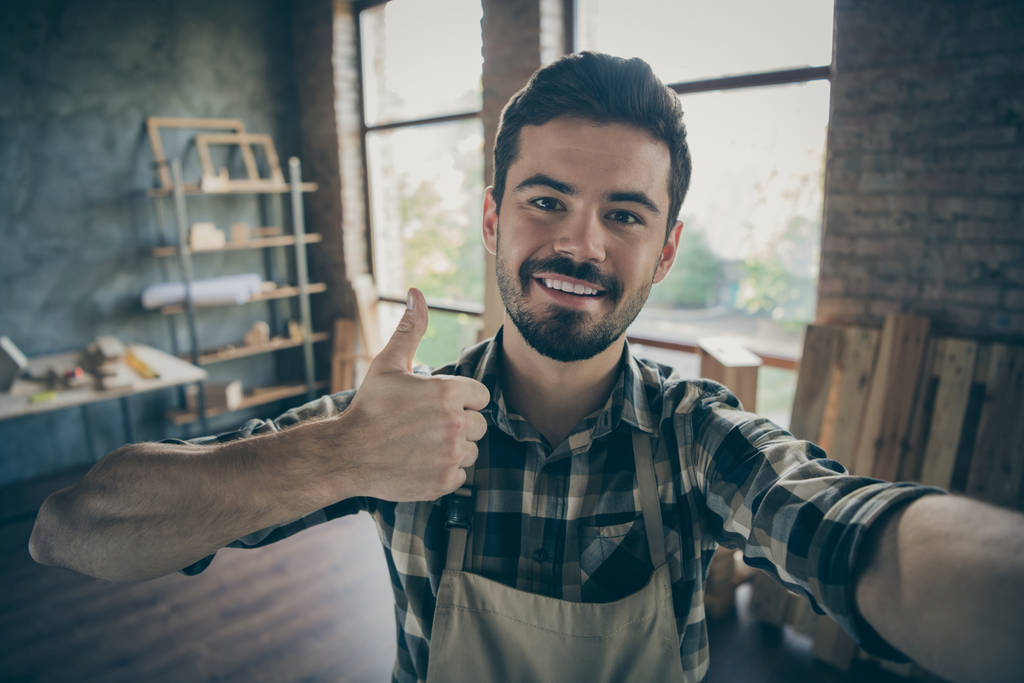 Closeup photo of handsome guy master raising thumb up making selfies in new own wooden business industry studio looking customers woodwork shop garage indoors - Photo, Image