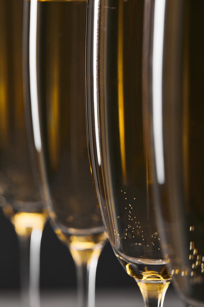 close-up van mousserende wijn in glazen voor het vieren van kerstavond op grijs - Foto, afbeelding