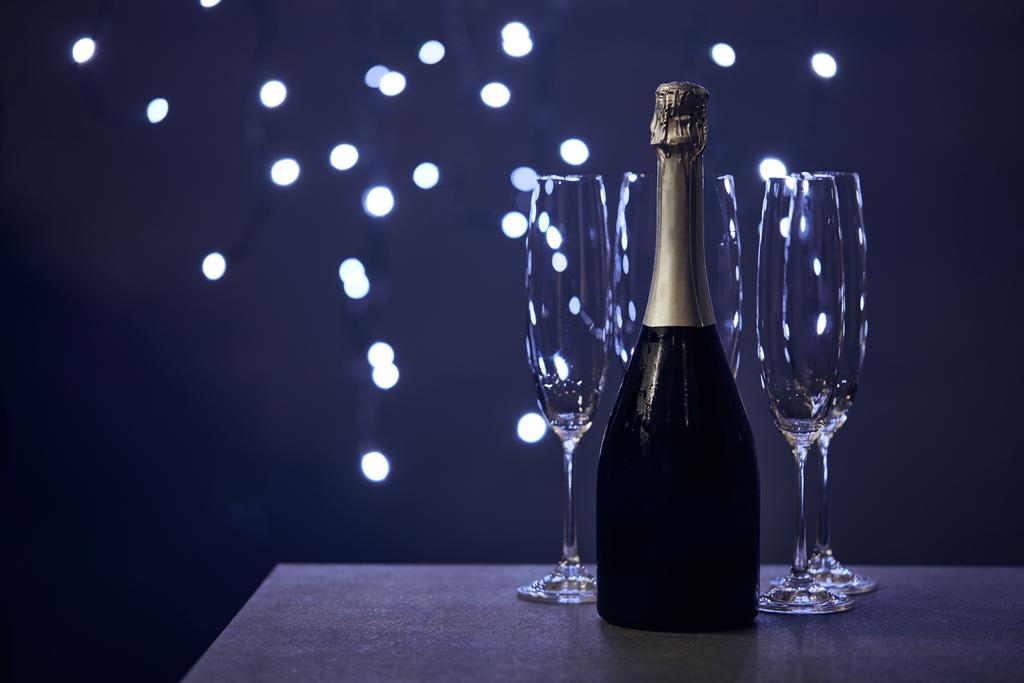 bottle of champagne and glasses with blurred christmas lights  - Photo, Image