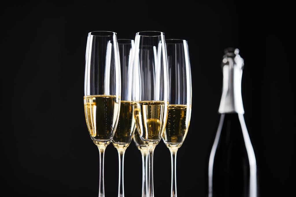 glasses and bottle of champagne for celebrating christmas, isolated on black  - Photo, Image