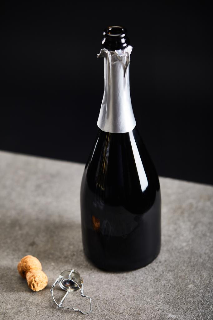 Flasche Champagner mit Korken zur Weihnachtsfeier auf Schwarz - Foto, Bild