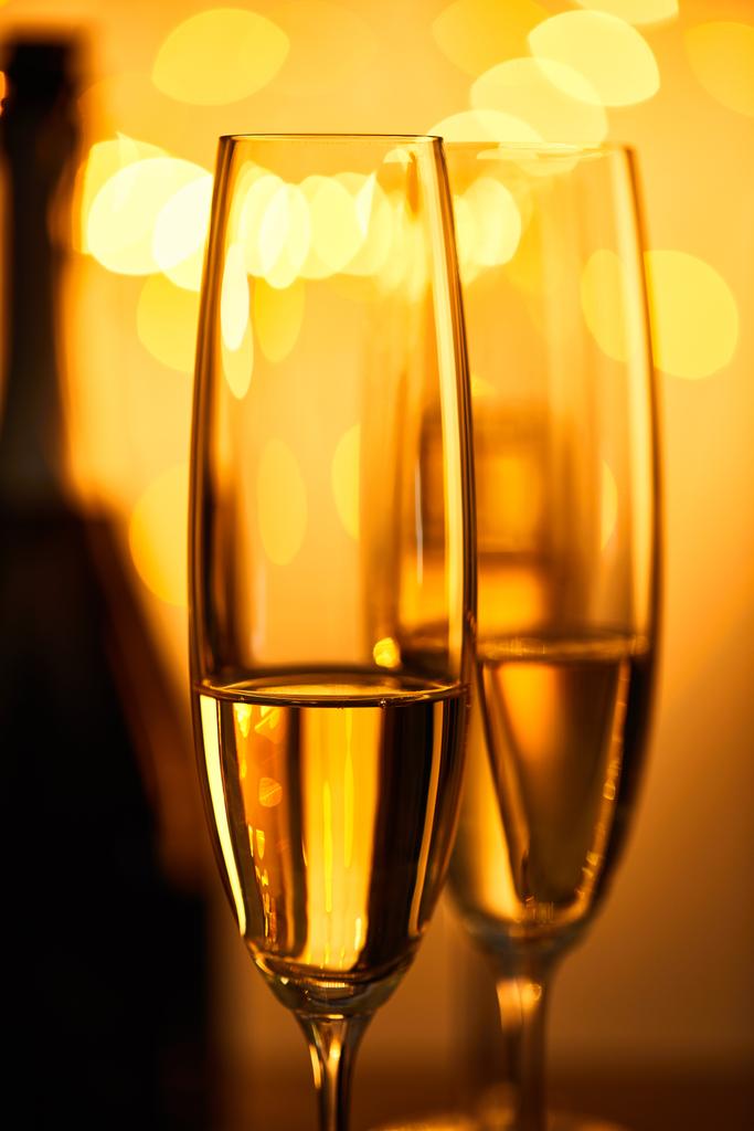 verres de champagne avec bouteille floue et lumières de Noël jaunes
 - Photo, image