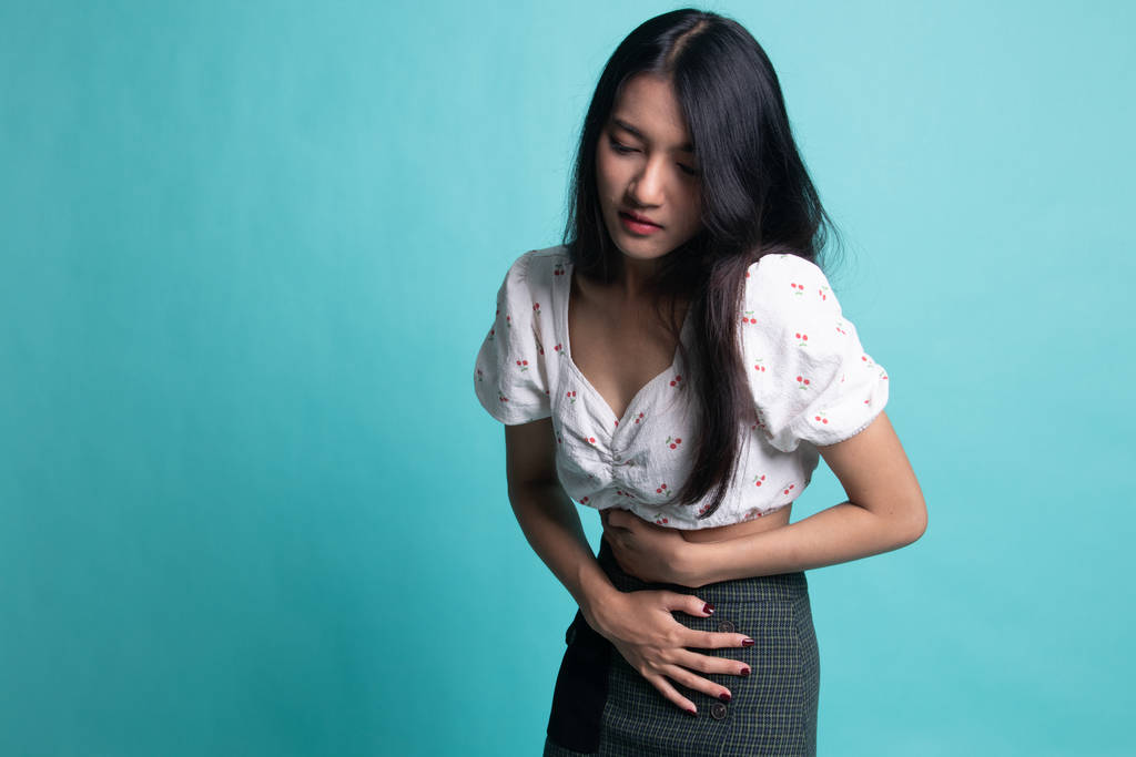 Jeune femme asiatique a mal à l'estomac
 - Photo, image