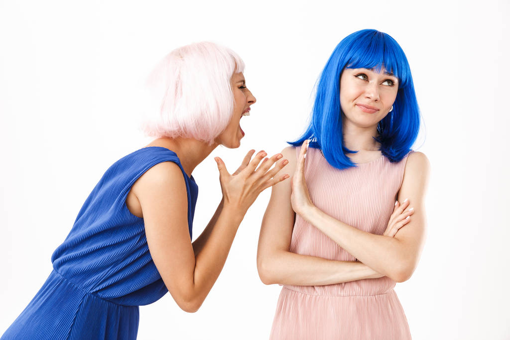 Ritratto di donna arrabbiata con una parrucca rosa che urla alla ragazza confusa mostrando un gesto di stop
 - Foto, immagini