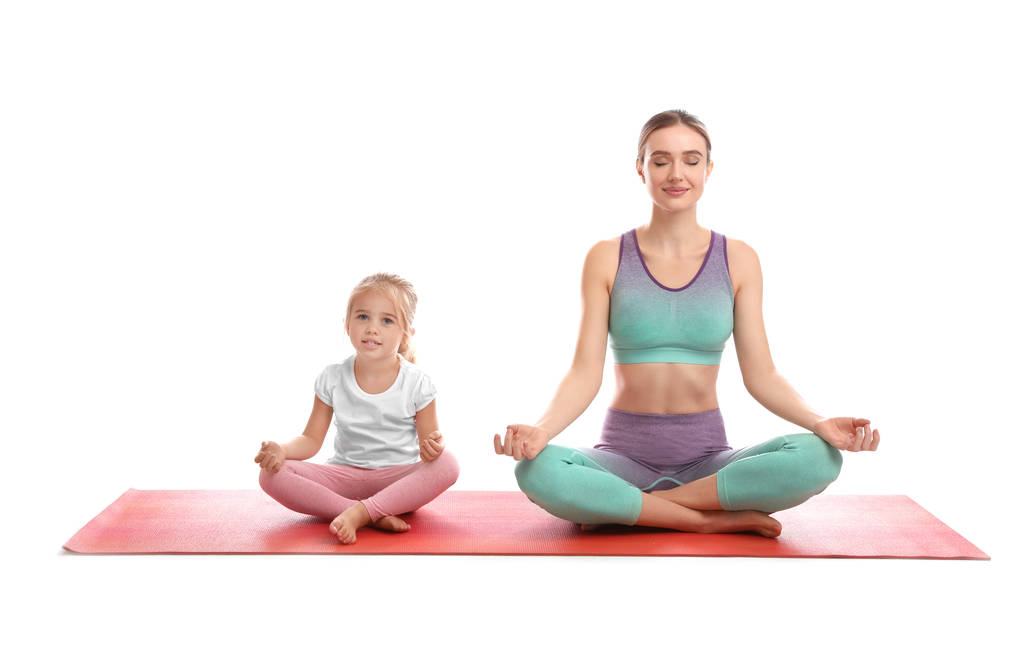 Jonge vrouw en haar dochter doen oefeningen geïsoleerd op wit. Thuis fitness - Foto, afbeelding