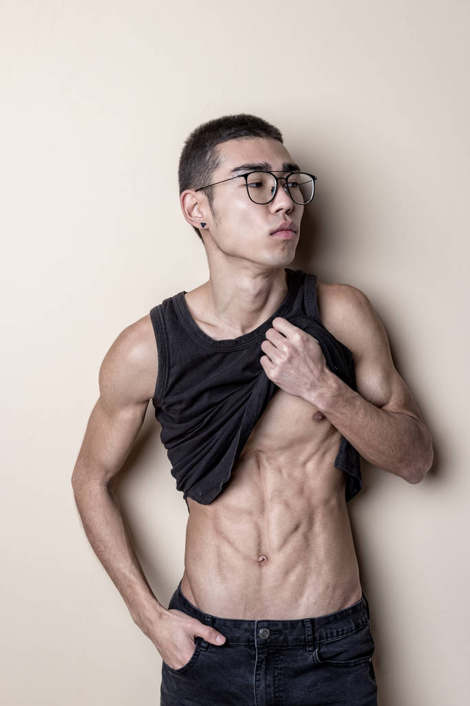 jong sexy man in bril poseren en toon uw lichaam - Foto, afbeelding