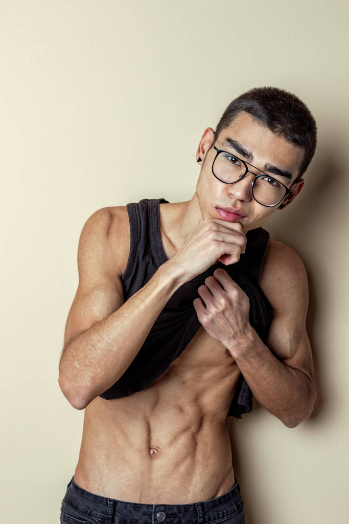 jong sexy man in bril poseren en toon uw lichaam - Foto, afbeelding
