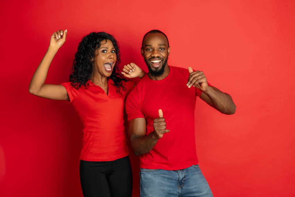junge emotionale afrikanisch-amerikanische Mann und Frau auf rotem Hintergrund - Foto, Bild
