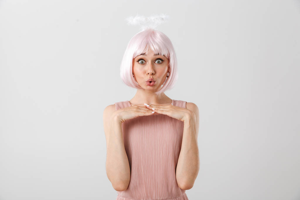 Retrato de mulher encantadora engraçada vestindo peruca rosa e halo de brinquedo olhando para a câmera enquanto sorria
 - Foto, Imagem