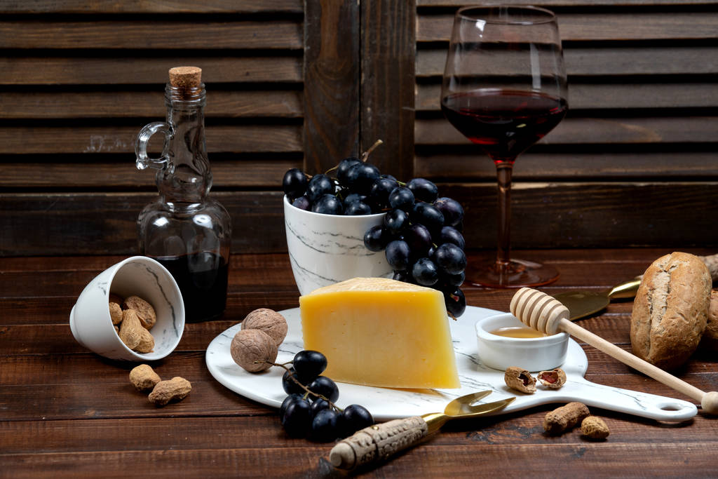 fatia de parmesão servida com vinho e uva
 - Foto, Imagem