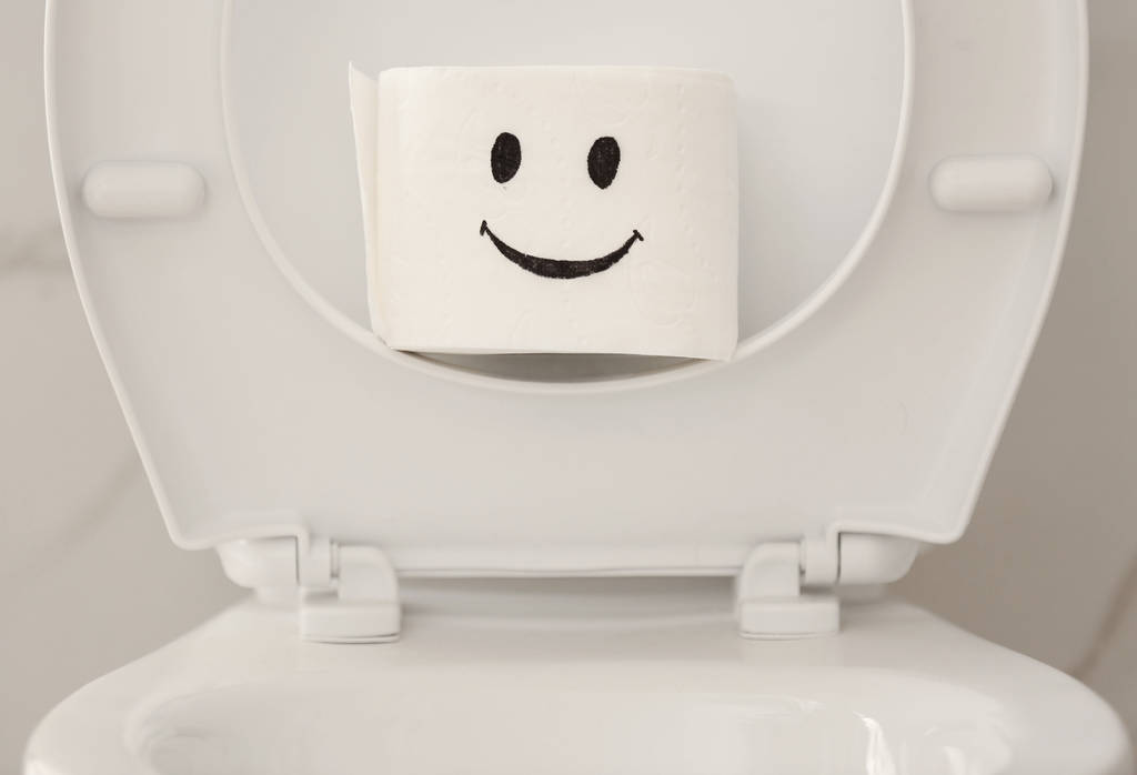 Рулон бумаги со смешным лицом на унитазе в ванной, крупным планом
 - Фото, изображение