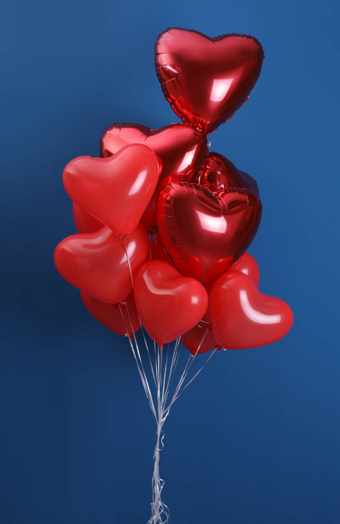 Manojo de globos en forma de corazón sobre fondo azul. Celebración de San Valentín
 - Foto, imagen
