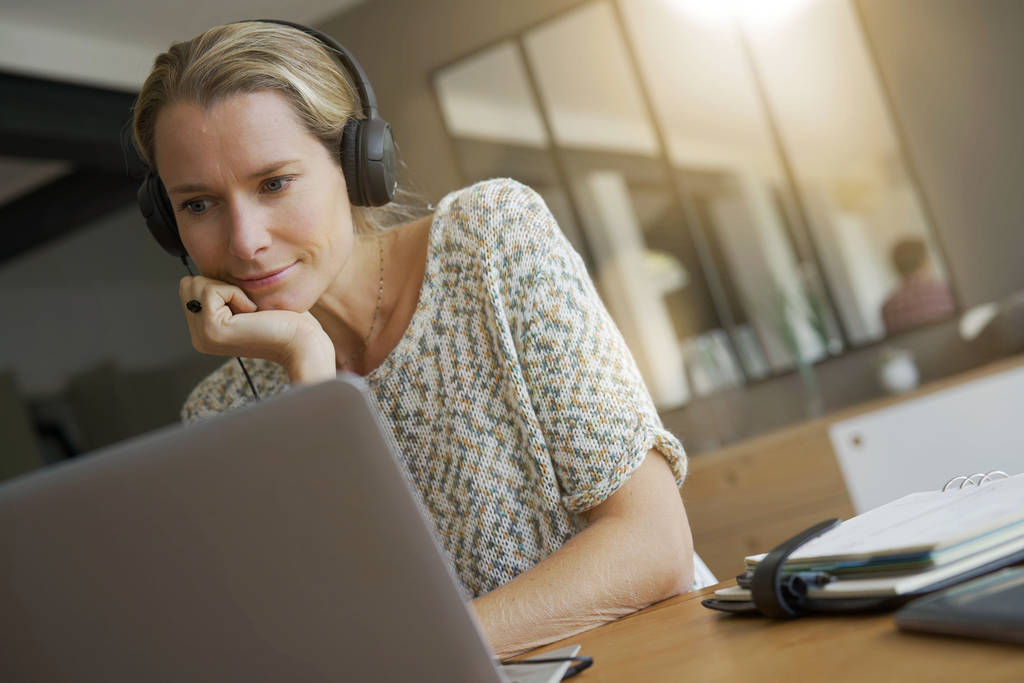 jeune femme blonde travaillant dans un bureau avec écouteurs
 - Photo, image