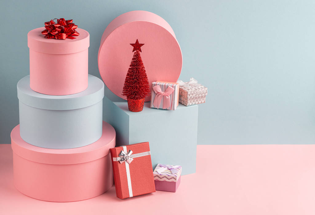 Rózsaszín és varangy ajándékdobozok és piros karácsonyfa türkiz háttér - Fotó, kép