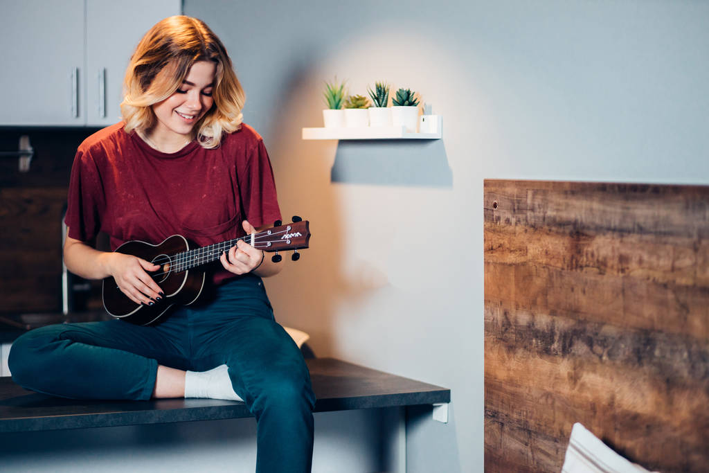 autodidakta nő játszik ukulele otthon - Fotó, kép