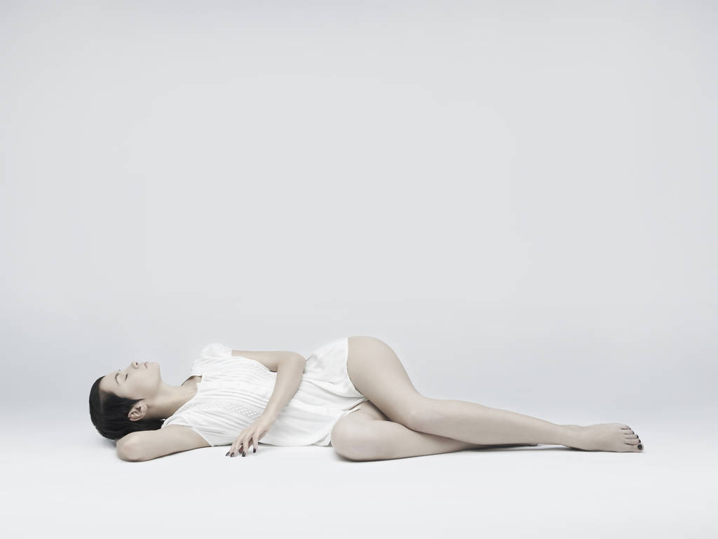 Mulher bonita elegante deitado no fundo branco
 - Foto, Imagem