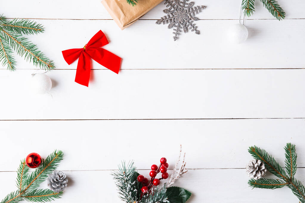 Krásné vánoční kompozice na dřevěném bílém pozadí s vánoční dárkové krabice, zasněžené jedlové větve, jehličnany, skořice sušené ovoce, sváteční dekorace, karamelová tyčinka. Nový rok. Horní pohled, kopírovací prostor. - Fotografie, Obrázek