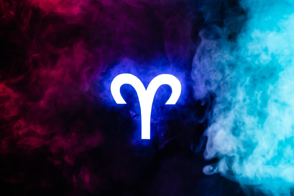 blu illuminato segno zodiacale Ariete con fumo colorato su sfondo
 - Foto, immagini