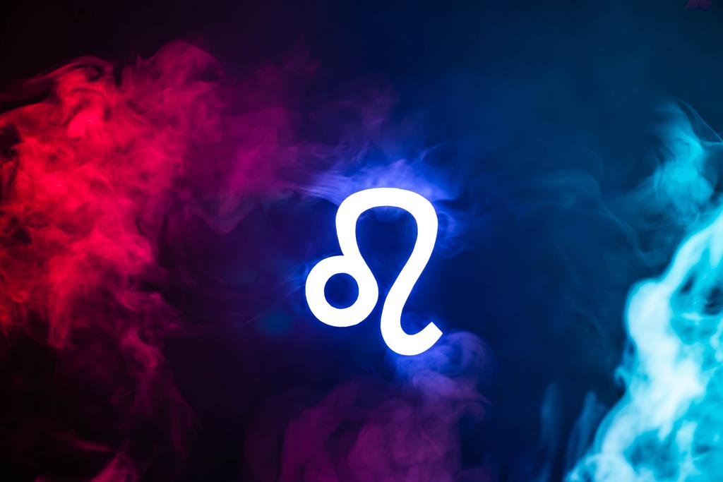 signo zodiacal Leo iluminado azul con humo de colores en el fondo
 - Foto, Imagen
