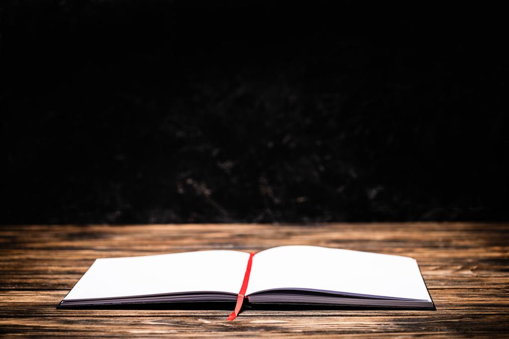 открытая книга с красной закладкой на деревянном столе
 - Фото, изображение