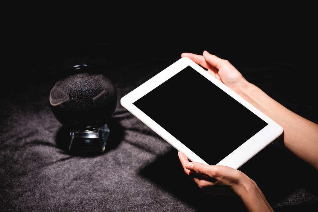 обрезанный вид астролога, держащего цифровой планшет возле хрустального шара на черной бархатной ткани
 - Фото, изображение