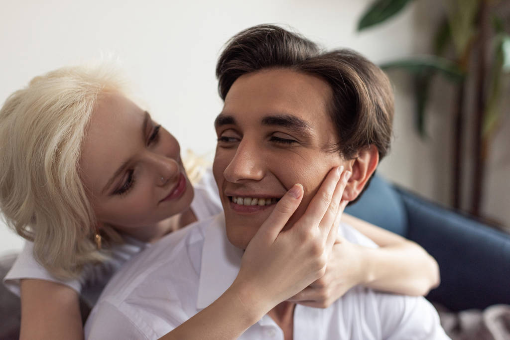 Sorrindo menina loira tocando namorado rosto em casa
 - Foto, Imagem