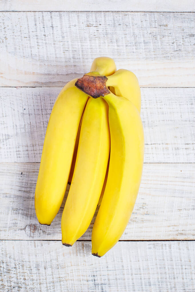 Dojrzały banan do diety i sportu na białym drewnianym tle - Zdjęcie, obraz