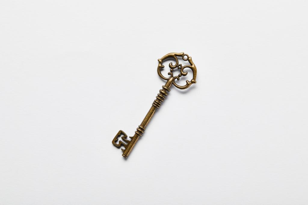 Beyaz arkaplandaki vintage anahtarının üst görünümü - Fotoğraf, Görsel
