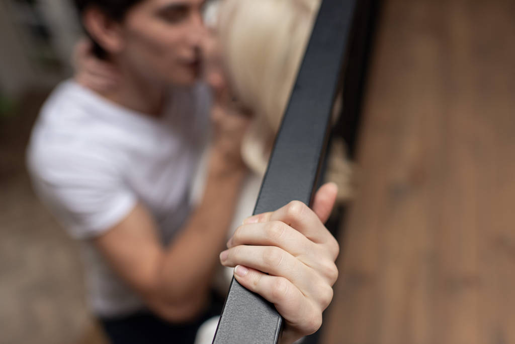 Selective focus of couple kissing by balcony railing - Photo, Image