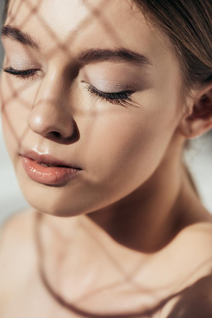 retrato de menina bonita com olhos fechados e sombras no rosto em cinza
 - Foto, Imagem