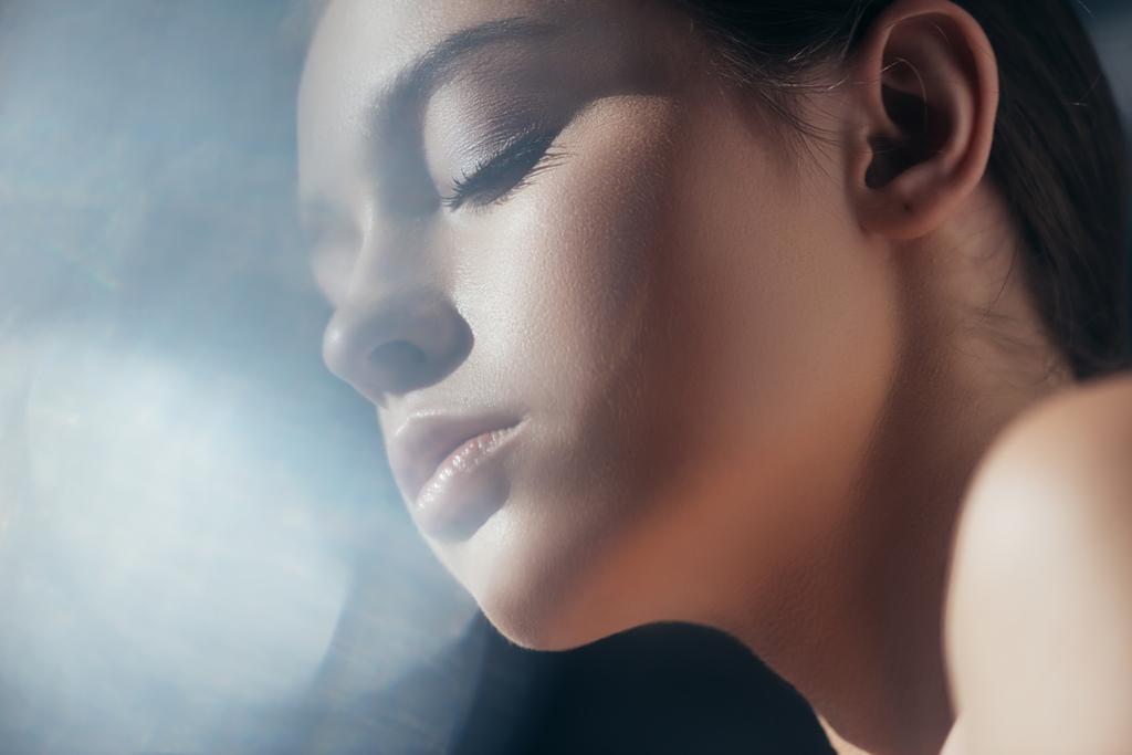 portrait of attractive tender girl on grey with lens flares - Photo, Image