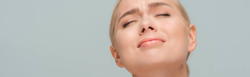 plan panoramique de femme bouleversée avec acné sur le visage isolé sur gris
  - Photo, image