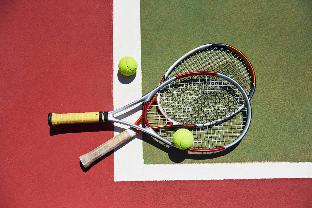 Uma raquete de tênis e uma nova bola de tênis em um campo de tênis pintado na hora. - Foto, Imagem