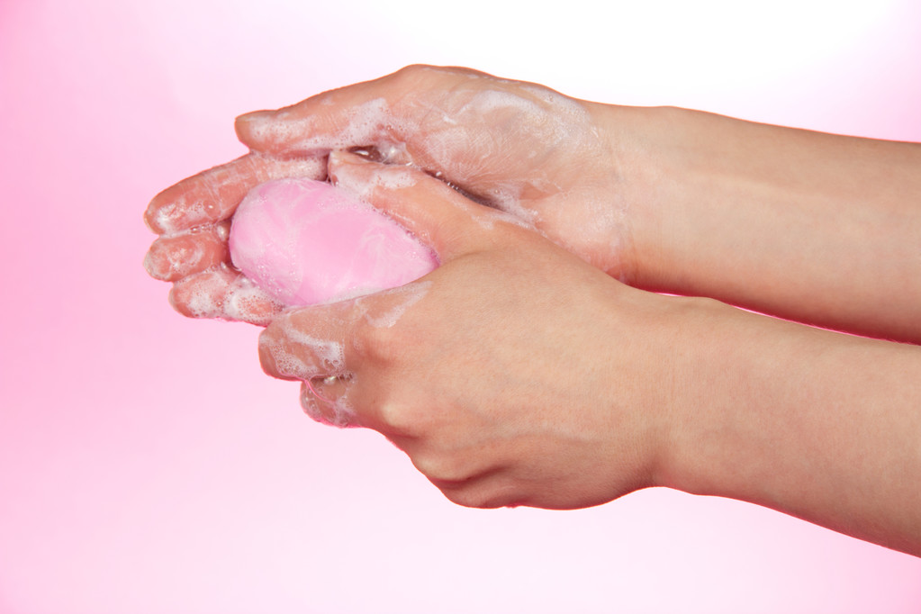 Pièce de savon parfumé dans les mains féminines sur un fond rose
 - Photo, image