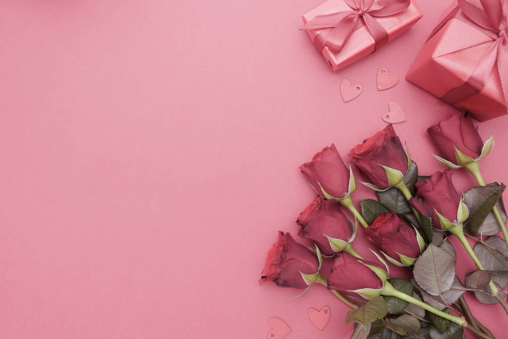 Κόκκινα τριαντάφυλλα και κουτί δώρου με κορδέλα, πάνω από το κόκκινο φόντο επίπεδη θέσει. Ημέρα του Αγίου Βαλεντίνου, Γενέθλια αφηρημένη φόντο με αντίγραφο χώρου. - Φωτογραφία, εικόνα