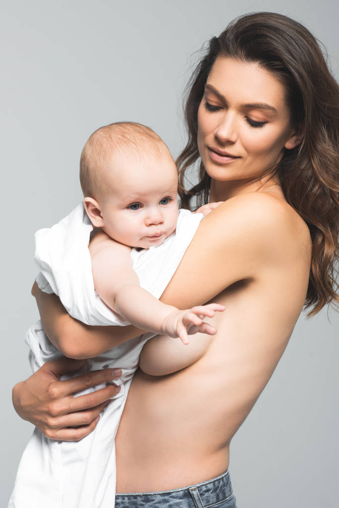 portrait of nude mother holding baby boy, isolated on grey - Photo, Image