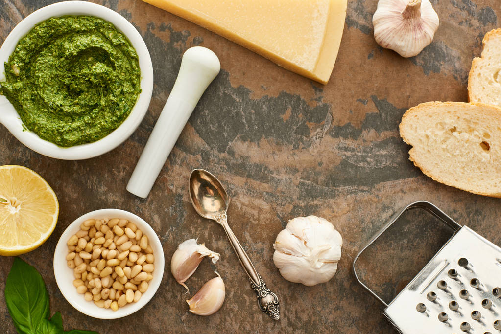 Pesto sosunun üst görüntüsü, malzemeler ve ekmek taş yüzeyde. - Fotoğraf, Görsel